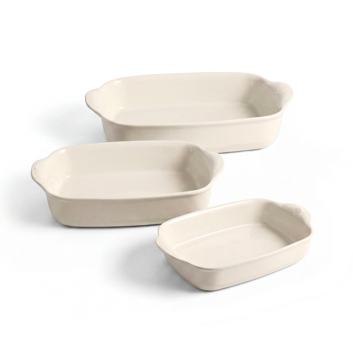 Three rectangular ceramic baking dishes in a matching warm off-white color, arranged by size on a clean white background.