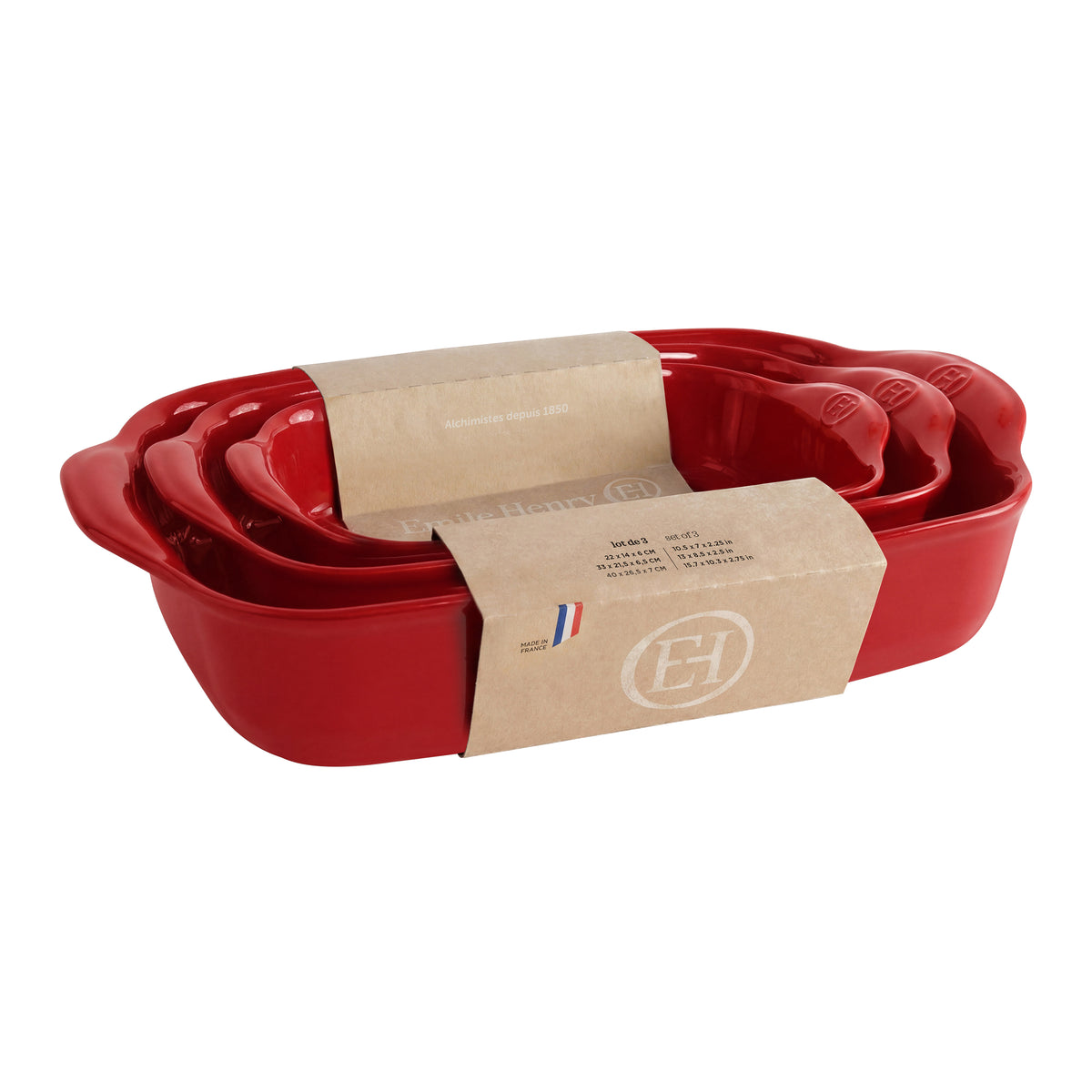 A set of nested red ceramic baking pans with a brown kraft paper band around the middle, photographed on a clean white background.